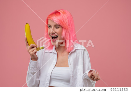 Cheerful woman performing a song with a banana mic 96111383