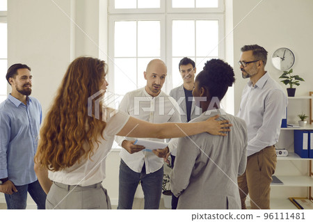 Corporative business training in office with people standing in round and listening man colleague. 96111481