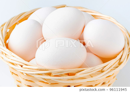 Eggs | Many white raw eggs in a wooden basket 96111945