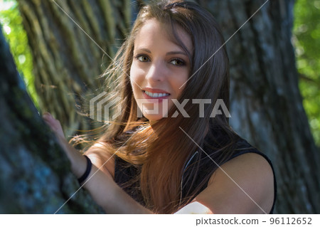 young woman resting on tree at the park in sunshine young woman resting on tree at the park in sunshine 96112652