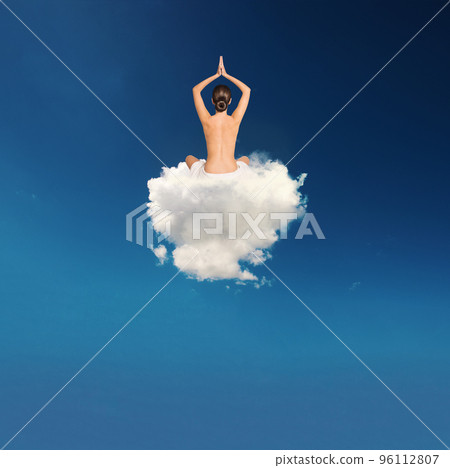 Young girl practices yoga over a cloud 96112807