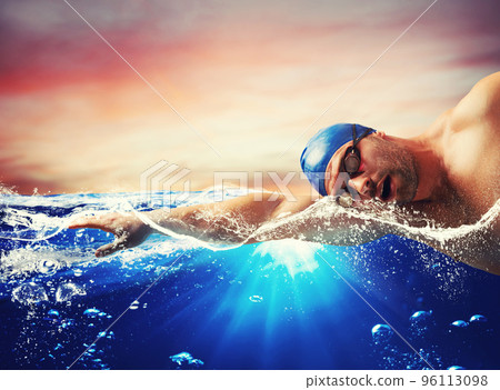 Boy swims in a blue deep water 96113098