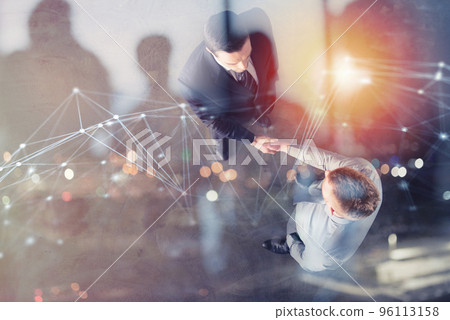 Handshaking business person in office with network effect. concept of teamwork and partnership. double exposure 96113158