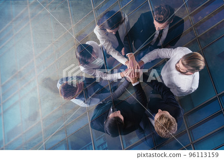 Business people putting their hands together. Concept of integration, teamwork and partnership. double exposure 96113159
