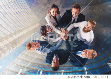 Business people putting their hands together. Concept of integration, teamwork and partnership. double exposure Business people putting their hands together. Concept of integration, teamwork and partnership. double exposure 96113161