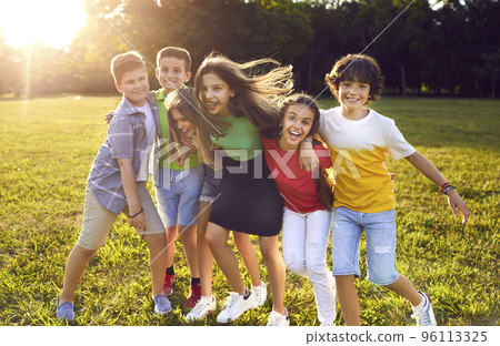 Group of happy cheerful little children playing in park and having good time together Group of happy cheerful little children playing in park and having good time together 96113325