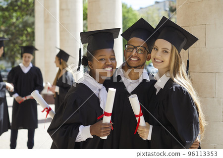 Portrait of three university graduate friends with diplomas in their hands outdoors after ceremony. Portrait of three university graduate friends with diplomas in their hands outdoors after ceremony. 96113353