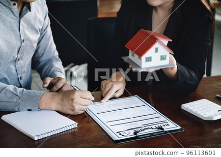Concept of signing loan, refinancing, buying house and land,rental accommodation, male client signing contract with female real estate agent to Buy a dwelling 96113601