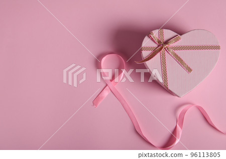Flat lay. Still life with pink satin ribbon and pink pastel heart shaped gift box on color background. Breast Cancer Awareness Campaign. October 1. Assistance, help, support. Health care and medicine 96113805