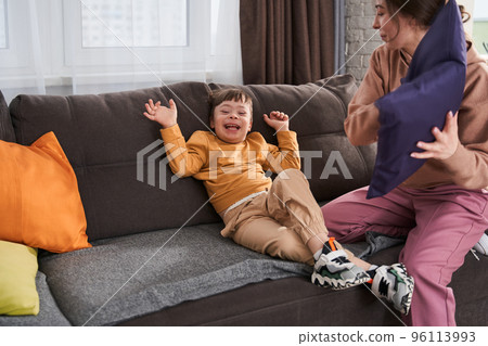 Overjoyed little boy with genetic disorder laughing out loud while playing 96113993