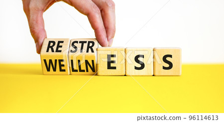 Restress for wellness symbol. Concept words Restress and Wellness on wooden cubes. Businessman hand. Beautiful yellow table white background. Business Restress for wellness concept. Copy space. Restress for wellness symbol. Concept words Restress and Wellness on wooden cubes. Businessman hand. Beautiful yellow table white background. Business Restress for wellness concept. Copy space. 96114613