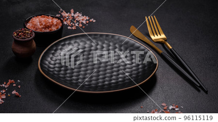 Empty black plate over dark stone background with free space 96115119