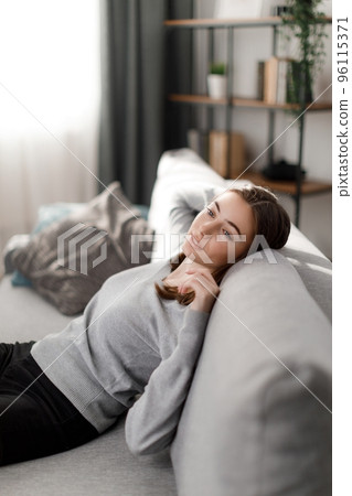 Woman relaxing on couch Woman relaxing on couch 96115371