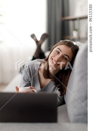 Woman resting with tea and laptop 96115380