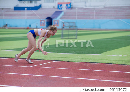 Young caucasian woman is engaged in jogging at the stadium outdoors. Young caucasian woman is engaged in jogging at the stadium outdoors. 96115672