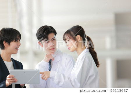 Female doctor pointing at the tablet held by MR and speaking _1 96115687