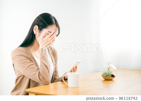 A woman who is shocked to see a smartphone with broken heart 96118742