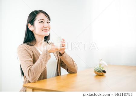 Japanese woman drinking white hot water, ginger hot water, tea at home (onkatsu) 96118795