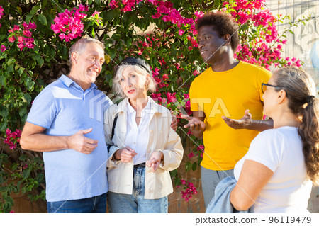 Happy multiracial couples discussing events at sunny day in the park Happy multiracial couples discussing events at sunny day in the park 96119479