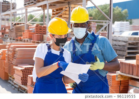 Two workers in masks keep track of the number of redbricks Two workers in masks keep track of the number of redbricks 96119555