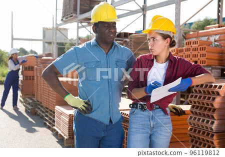 Warehouse workers in outdoor construction material storage 96119812