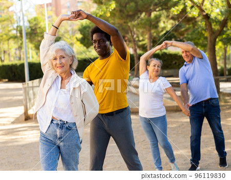 Elderly woman enjoying dance with partner in garden 96119830