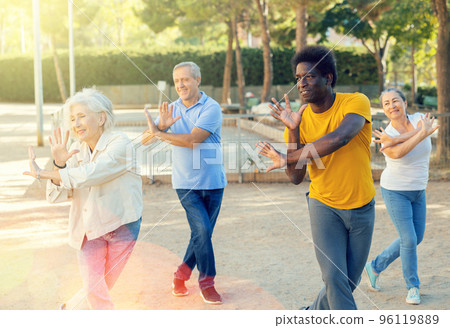 Group of multiracial friends getting together outdoors and dancing simple moves on a sunny day in autumn 96119889