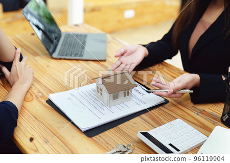 Asian female bank employee asking a customer to read the contract before signing to agree to buy a house, real estate concepts. 96119904