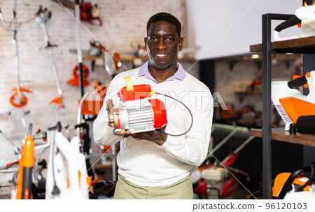 Man with pump in gardening tools store 96120103