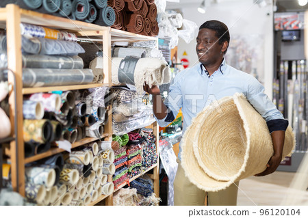 Male shopper chooses floor mat in store 96120104