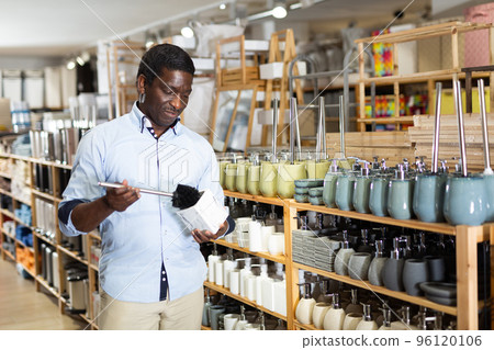Male shopper chooses toilet brush at hardware store 96120106