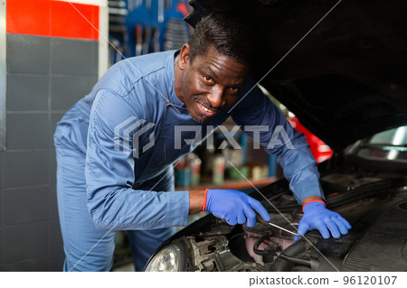 Skilled mechanic technician working at service station Skilled mechanic technician working at service station 96120107