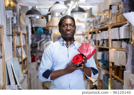 Smiling african american man buying table lamp in store Smiling african american man buying table lamp in store 96120140