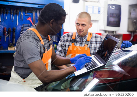 Mechanic and assistant working at service 96120200