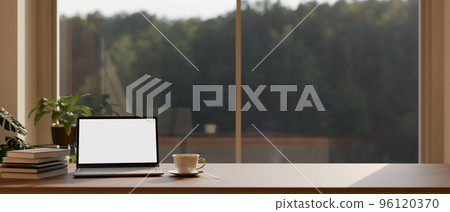 Comfortable home workspace tabletop close-up with laptop mockup against the window 96120370