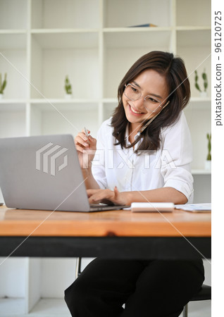 Professional Asian businesswoman talking on the phone with her business client Professional Asian businesswoman talking on the phone with her business client 96120725