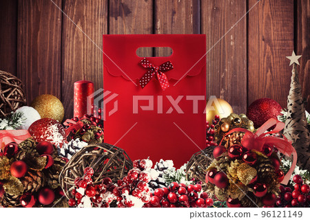 Christmas gift box presented in the middle of Christmas decorations on wooden planks 96121149