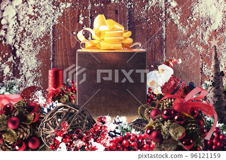 Christmas gift box presented in the middle of Christmas decorations on wooden planks Christmas gift box presented in the middle of Christmas decorations on wooden planks 96121159