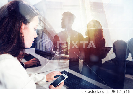 Business people work together in office with workstation in the foreground. Concept of teamwork and partnership. double exposure with light effects Business people work together in office with workstation in the foreground. Concept of teamwork and partnership. double exposure with light effects 96121546