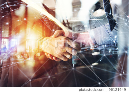 Handshaking business person in the office. concept of teamwork and partnership. double exposure Handshaking business person in the office. concept of teamwork and partnership. double exposure 96121649