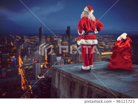Santa Claus looks down on the city waiting to deliver the presents 96121723