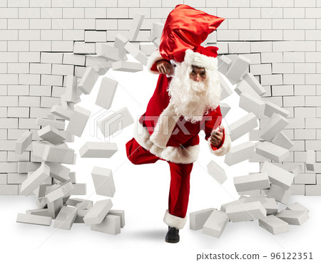 Santa Claus enters to deliver the gift by making a hole in the wall Santa Claus enters to deliver the gift by making a hole in the wall 96122351