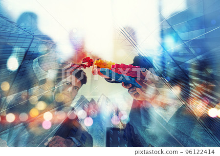 Working group of businessmen find the agreement by holding a piece of gear in hand. concept of teamwork and business partnership. double exposure 96122414