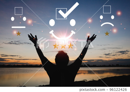 Silhouette young man standing with for check mark face emoticon smile on dark background Silhouette young man standing with for check mark face emoticon smile on dark background 96122426