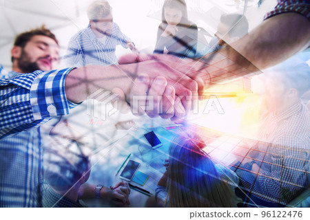 Handshaking business person in casual wear in the office. concept of teamwork and partnership. double exposure 96122476