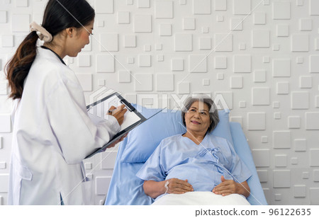 Young asian doctor examine the symptom of the elderly patient in the recovery room. Healthcare and medicine concept Young asian doctor examine the symptom of the elderly patient in the recovery room. Healthcare and medicine concept 96122635