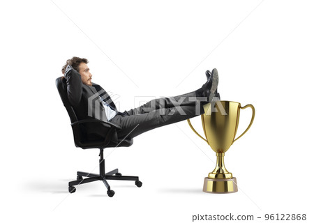 Winner businessman relaxing over a golden cup 96122868