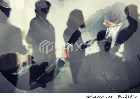 Handshaking business person in office. concept of teamwork and partnership. double exposure Handshaking business person in office. concept of teamwork and partnership. double exposure 96122979