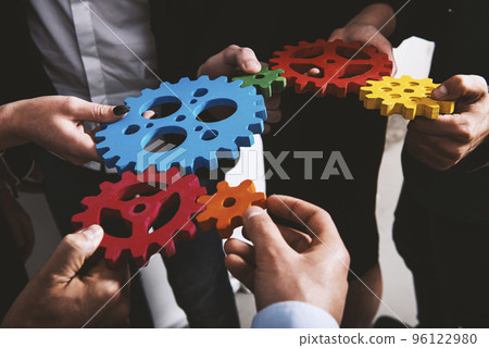 Business team connect pieces of gears. Teamwork, partnership and integration concept Business team connect pieces of gears. Teamwork, partnership and integration concept 96122980