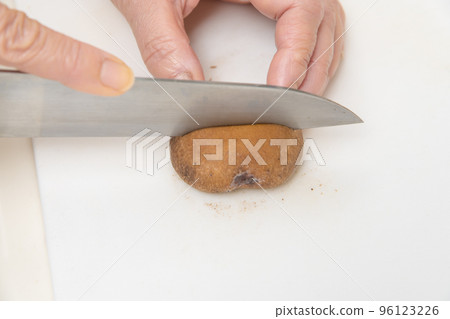 [A middle-aged housewife cuts a shiitake mushroom in half] 96123226